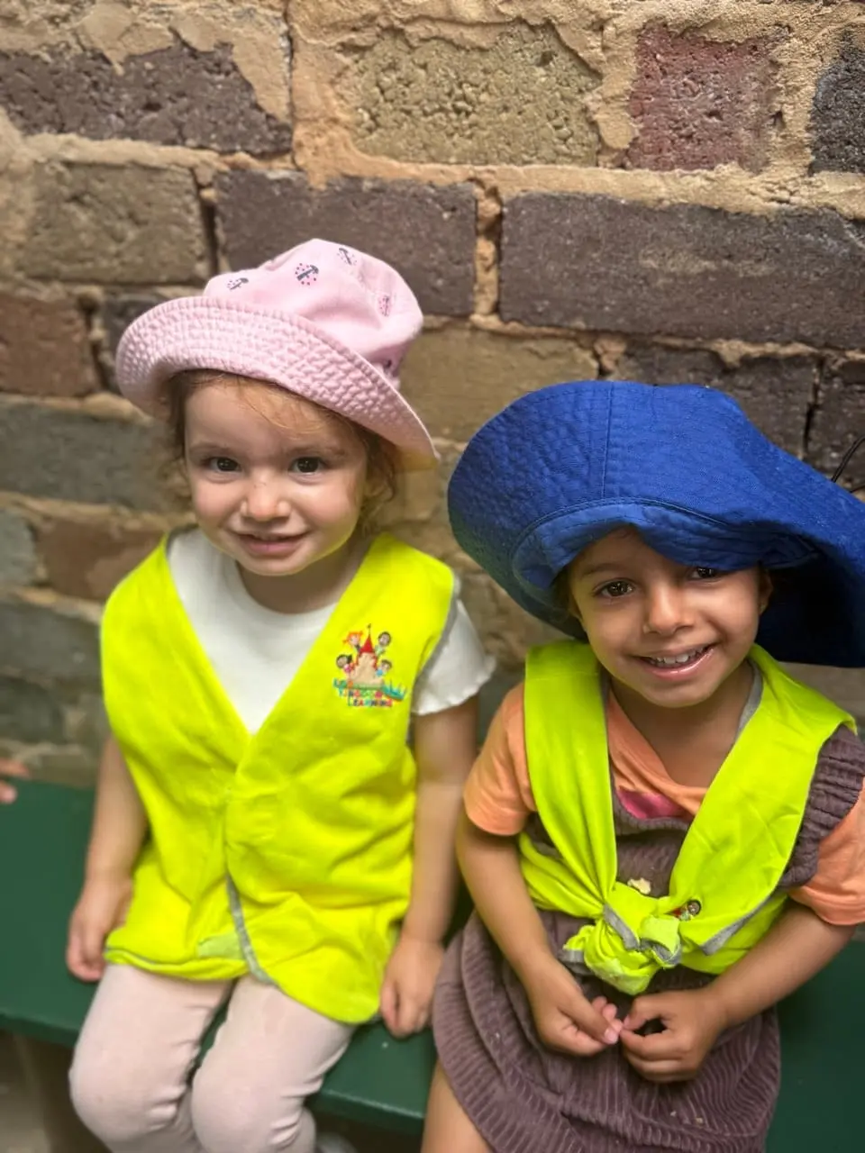 Two children dressed in chef hats sharing a playful cooking-themed moment.