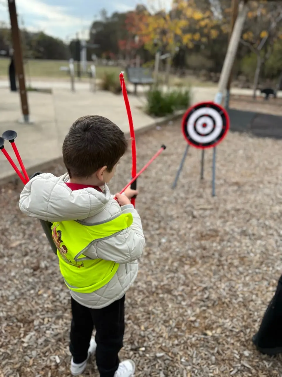 A child in a high-visibility vest taking part in a road safety excursion walk.