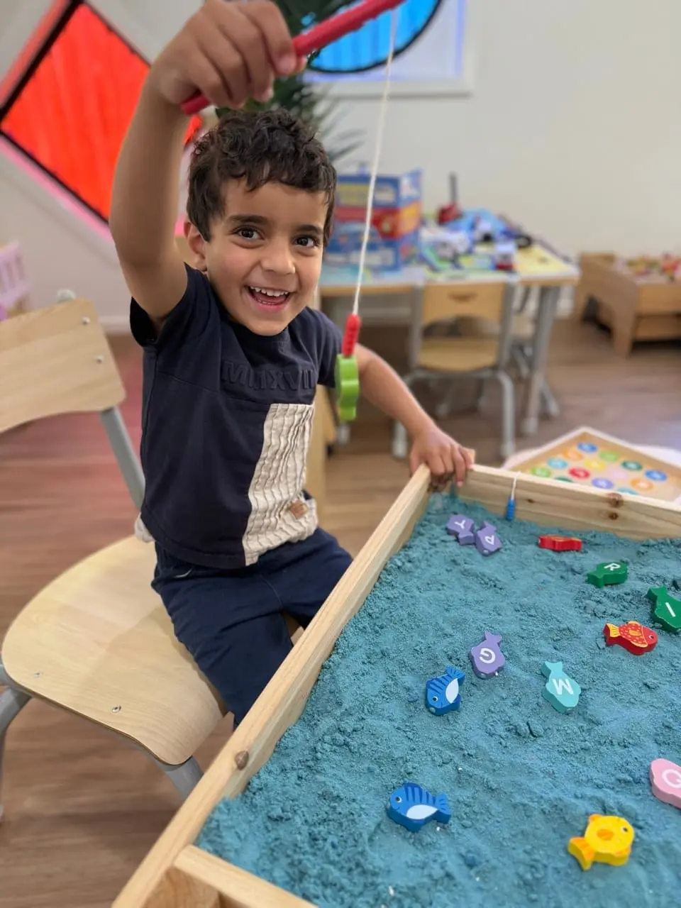 A bright Kids Kingdom learning room with tables, shelving, and play materials prepared for children.